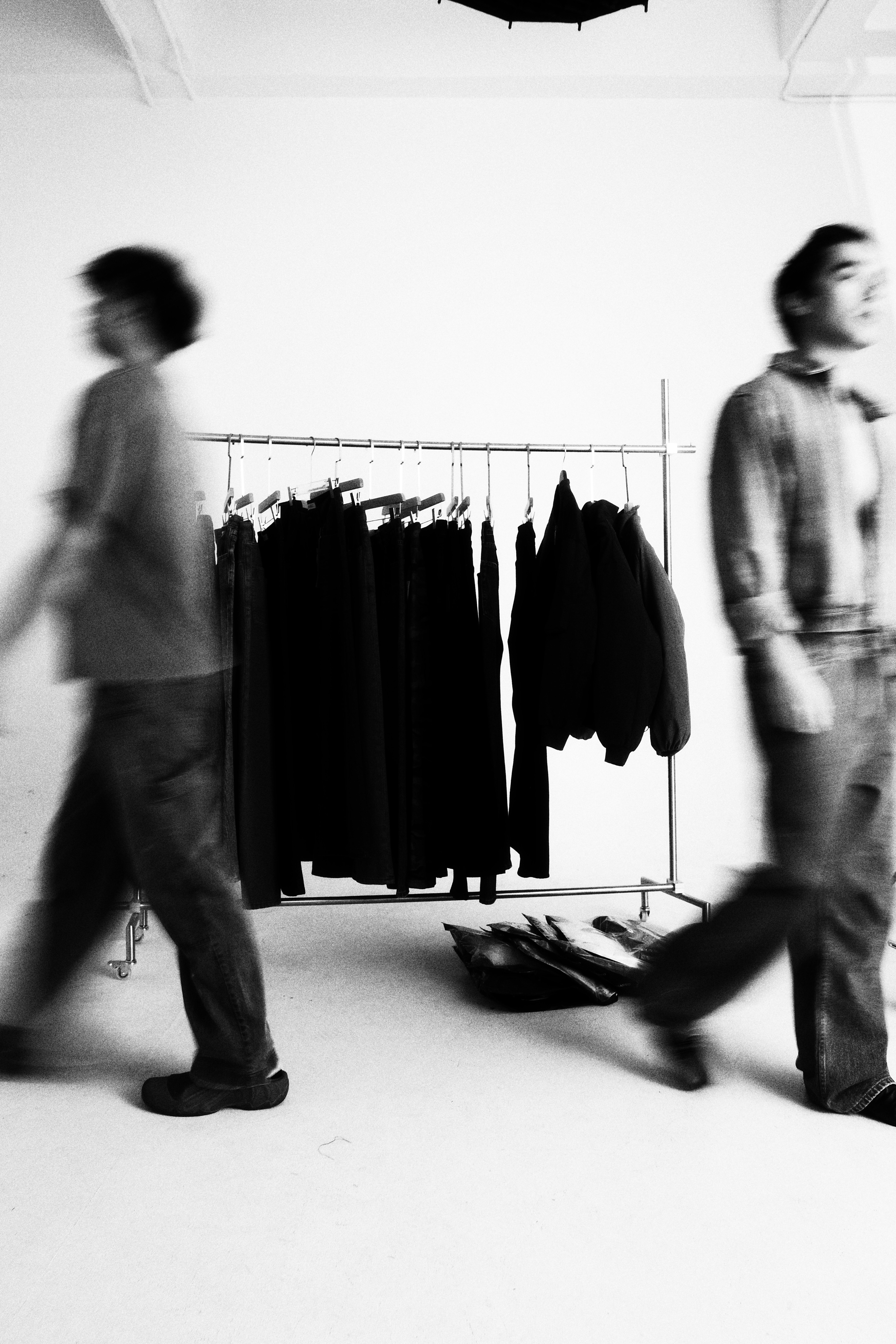 Styling studio with a curated clothing rack and motion-blurred figures